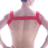 Back view of MetroMaleWear logo harness red adhesive tape strapped in an x-shaped pattern across a person’s back