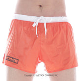 Bright orange metroMalewear iron sports swim trunks with white drawstring waistband and black logo patch on left leg