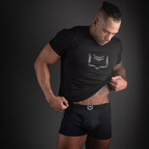 Black athletic t-shirt with a silver geometric logo on the chest featured in sheath 2.1 dual pouch trunks 3 pack bundle