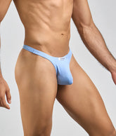 Light blue form-fitting thong made of smooth peachskin fabric with white label at waistband showing back side
