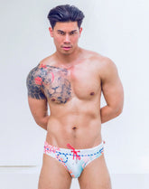 A muscular man models the 2EROS V10 Printed Swim Brief in Coralscape Blue against a white background.