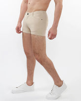Beige 3 inch stretch knit chino shorts with classic five-pocket design and black button closure for comfortable wear