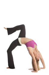A woman in a vibrant purple sports bra with white lace-up straps and black flared leggings performs an advanced yoga pose wearing 4-rth women’s classic yoga pant