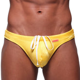 Bright yellow satin swim thong with white drawstrings and red MetroMaleWear brand tag for classic style and comfort