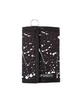 Black 80s velcro tri-fold wallet with white paint splatter pattern and silver metal ring at the top