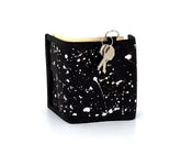 Black 80s velcro wallet with white paint splatter design and attached key ring with keys at the top