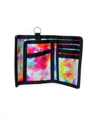 A vibrant tie-dye 80s velcro wallet with black trim and a metal ring at the top for easy carrying