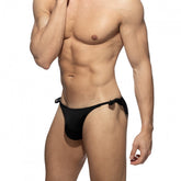 Muscular male torso wearing Addicted black multi-cord swim bikini brief against white background.