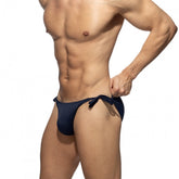 Muscular male torso modeling Addicted navy multi-cord swim bikini brief with side ties against a white background.