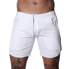 White athletic shorts featuring an elastic waistband with drawstring, side pockets, and curved hem detail.