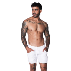 White athletic shorts featuring a drawstring waistband and side pockets on a tattooed model.