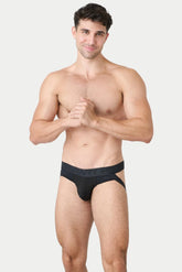 A muscular man wearing AWRY black lift jock thong underwear against a plain background.