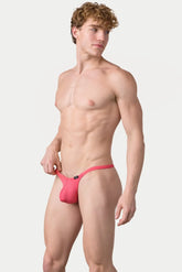 A shirtless male model wears bright pink AWRY Menswear Pulse V-string underwear against a white background.
