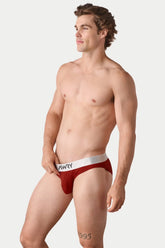 A man wearing red AWRY Pocket Brief V2 underwear with a white branded waistband against a white background.