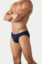 A man wearing AWRY Menswear Oasis Classic Swim Brief in navy against a white background.