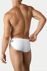 Rear view of a man wearing AWRY Menswear white Oasis Classic swim briefs, featuring a small black logo on the hip.