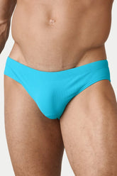A man wearing AWRY Menswear cyan ribbed classic swim brief on a plain background.