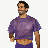 A smiling man wearing a purple mesh BIKE Athletic practice jersey against a plain background.