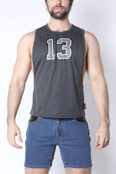A man wears a charcoal CellBlock 13 muscle tank top with the number 13 on the chest and blue jeans.