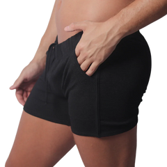Black knit athletic shorts with an elastic drawstring waistband and side pocket detailing.