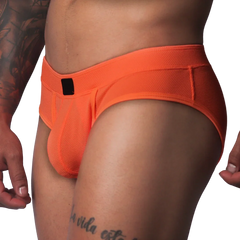 Bright orange textured mesh athletic brief with a wide waistband and a small black rectangular logo patch in front.