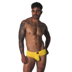 Bright yellow mesh low-rise brief with a centered rectangular black logo patch.