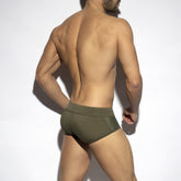 Rear view of a man wearing ES Collection khaki swim briefs against a white background.