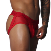Red jockstrap thong featuring sheer mesh fabric, a pouch, and a branded elastic waistband on a muscular torso.