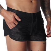 Black mesh athletic shorts with a drawstring waistband, side pockets, and short, curved hem design.
