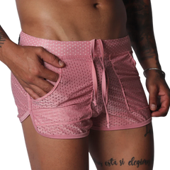 Pink, mesh athletic shorts with a drawstring waistband, side pockets, and curved hem detail.