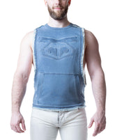 Man wearing a Mirage Blue Nasty Pig Emboss Brandmark Shredder sleeveless shirt with frayed edges and a front pocket.