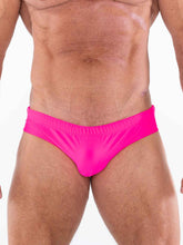 Torso of a muscular man wearing bright pink Full Kit Gear Buoy swim briefs against a white background.