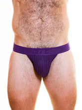 Torso wearing a purple mesh jockstrap with a branded waistband and chevron pattern.