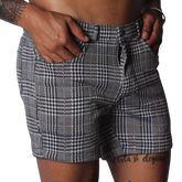 Men's slim-fit shorts in a black and white houndstooth glen plaid pattern with subtle gold thread accents.