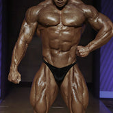 A muscular bodybuilder wearing black metro malewear posingwear ifbb pro posing suit briefs showing front view