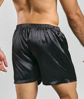 Black satin shorts from malebasics featuring a smooth glossy finish and elastic waistband for comfort