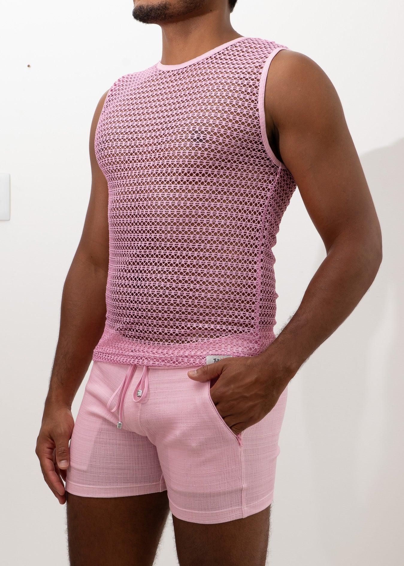 Pink crochet muscle tank top with mesh sleeveless design and subtle geometric pattern paired with matching drawstring shorts