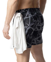Black swim trunks with bold white barbed wire pattern and white towel tied at the waist in barbed wire rugby short style