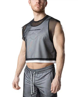 A man wearing the Nasty Pig Blur Crop Top in black mesh over a white layer, paired with grey athletic shorts.