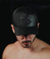 Shirtless man wearing a black Nasty Pig Hexxx Snout Cap with a tonal pig logo and hexagonal pattern.