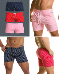 Three pairs of short, vertically striped swim trunks in navy, red, and pink with white drawstring waistbands.