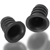 Two black OXBALLS Ribnips novelty items with ribbed cylindrical shapes and flared hollow openings against white.