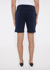Navy blue solid stretch knit shorts with buttoned back pockets shown from the back in a tailored modern cut