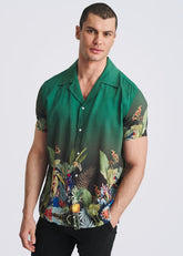 A male model wears a POSTMARC short-sleeve emerald modal shirt featuring a multi-colored fauna border print.