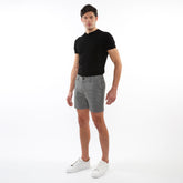 Black short-sleeved polo shirt with classic collar and buttoned placket paired with textured jacquard stretch chino shorts