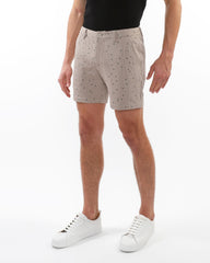 Beige textured jacquard stretch chino shorts with subtle black polka dot pattern and woven fabric detail