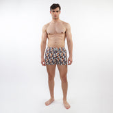 Printed swim short with mesh lining featuring vibrant orange navy blue and white tropical leaf and fruit pattern on fabric