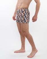 Printed swim short with mesh lining featuring vibrant tropical leaf and fruit pattern in navy orange and cream on white base