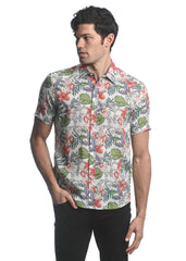 A man wearing an orchids tencel linen short-sleeved woven shirt with red green and gray tropical floral pattern on beige