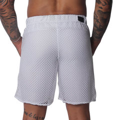 White mesh athletic shorts with an elastic waistband and a small black rectangular brand patch on the back.